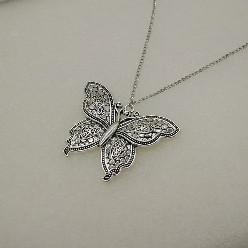 Silver butterfly pendant necklace on a light gray background