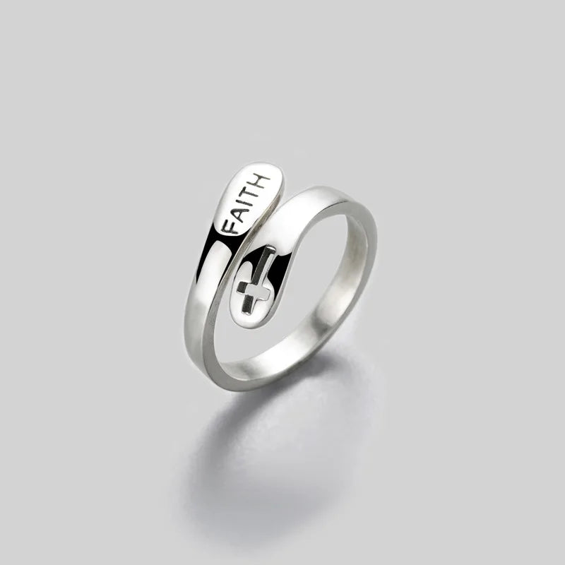 Silver ring with 'FAITH' engraving on a light gray background