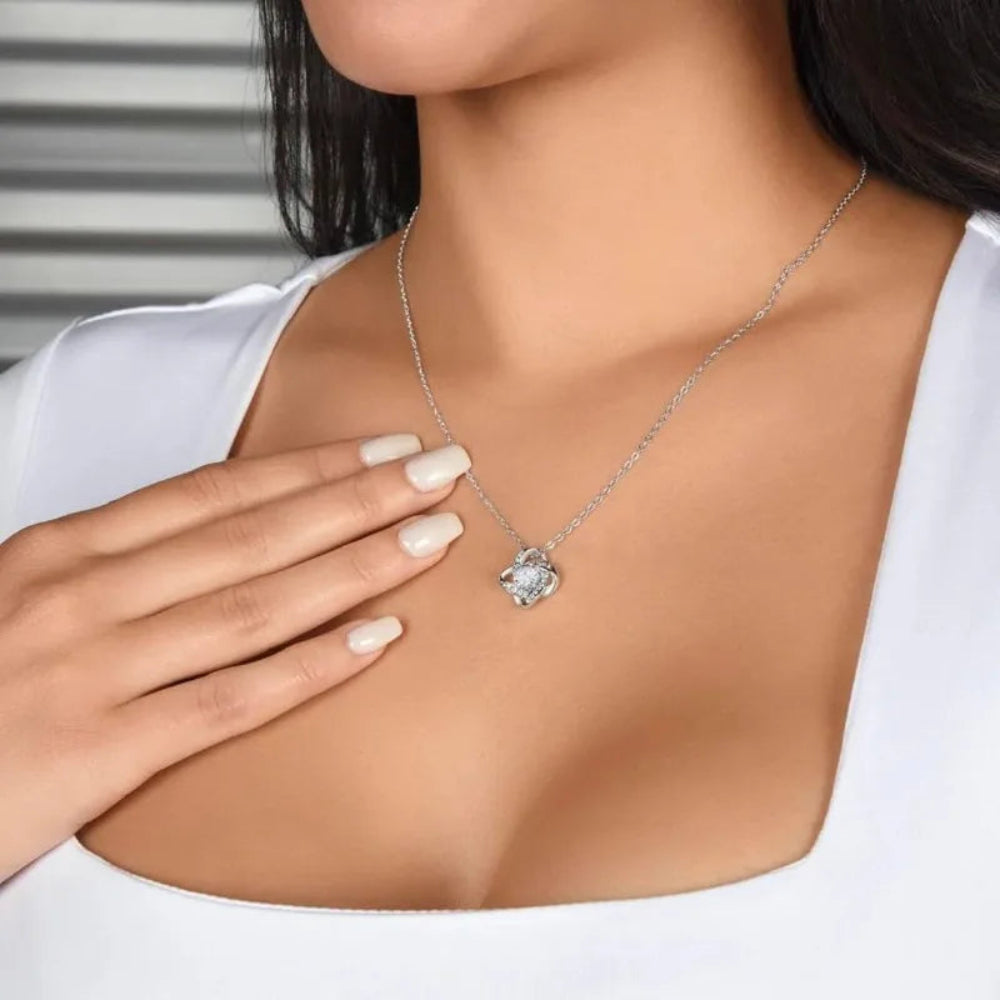 Woman wearing a silver necklace with a heart-shaped pendant