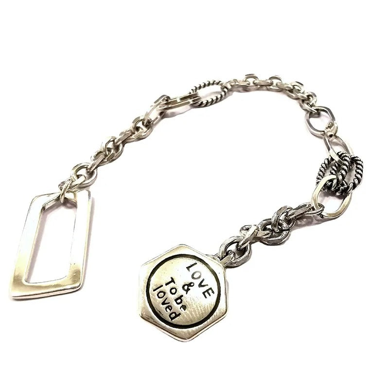 Silver bracelet with a heart-shaped charm on a white background