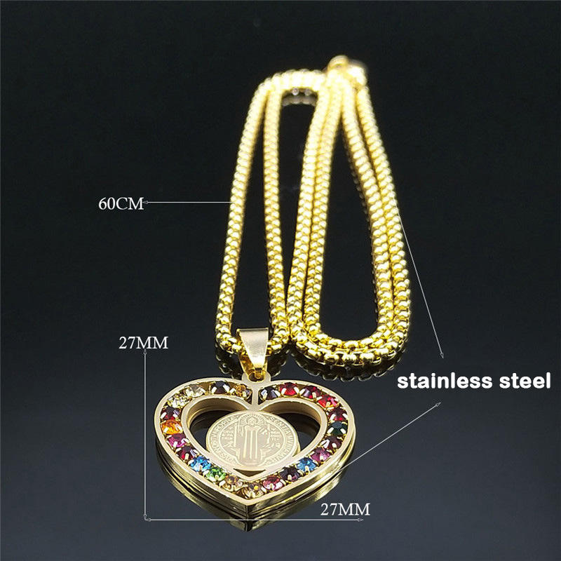 Gold necklace with a heart-shaped pendant featuring colorful stones on a black background.