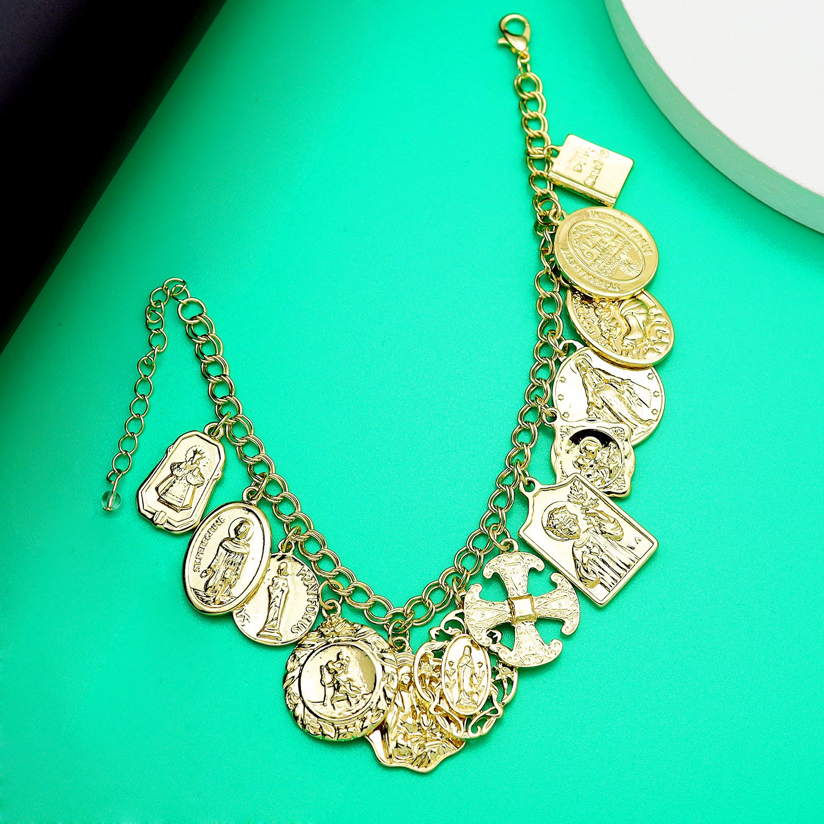 Gold bracelet with various charms on a green background