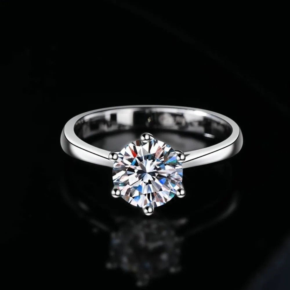 Silver ring with a large diamond on a black background