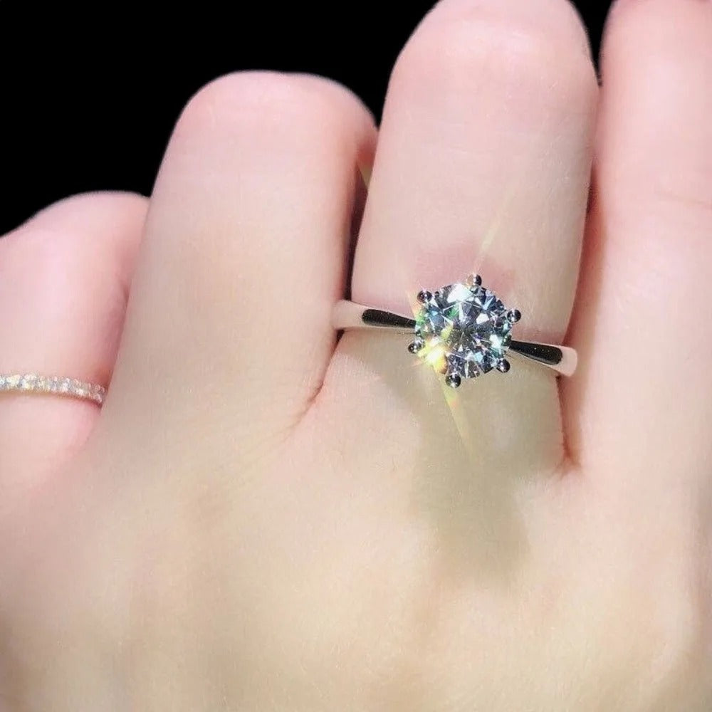 Diamond ring on a finger with a black background