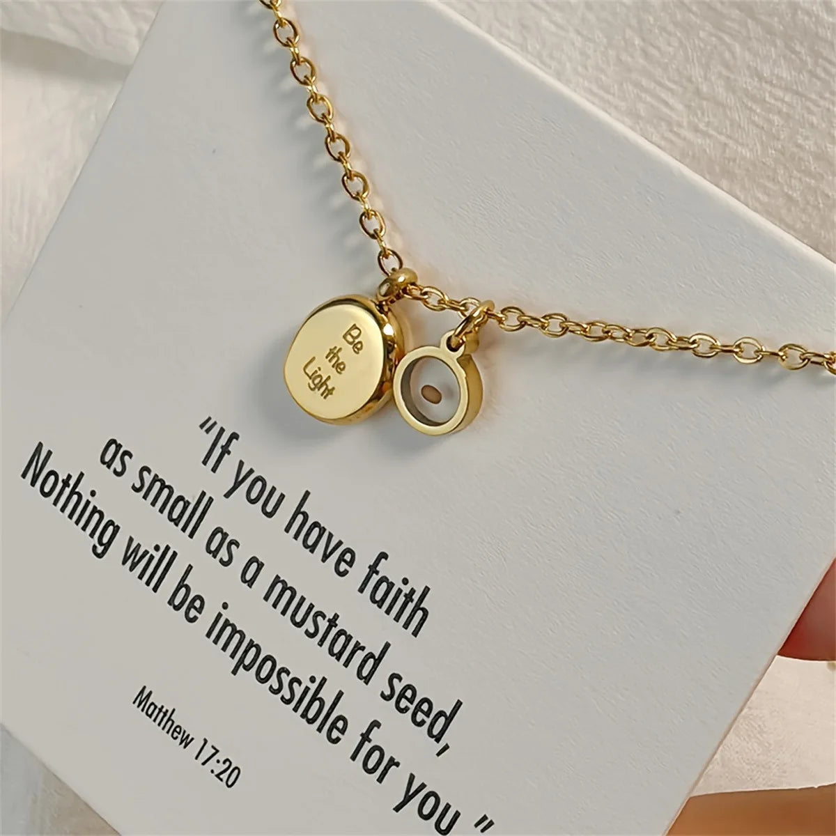 Gold necklace with motivational quote on a white card
