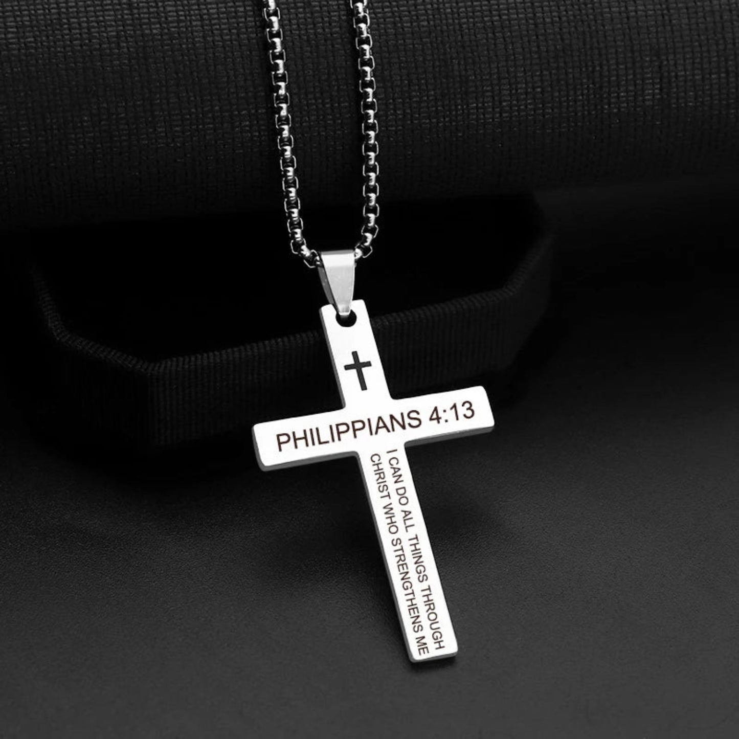 Silver cross pendant with 'Philippians 4:13' text on a black background