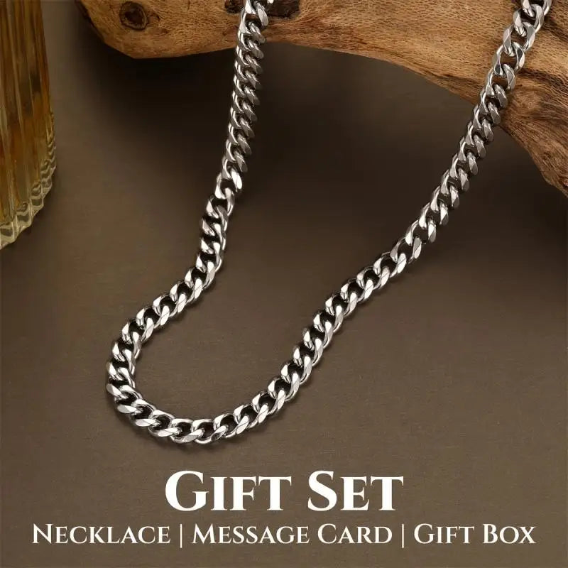 Silver chain necklace on a brown surface with text indicating a gift set.