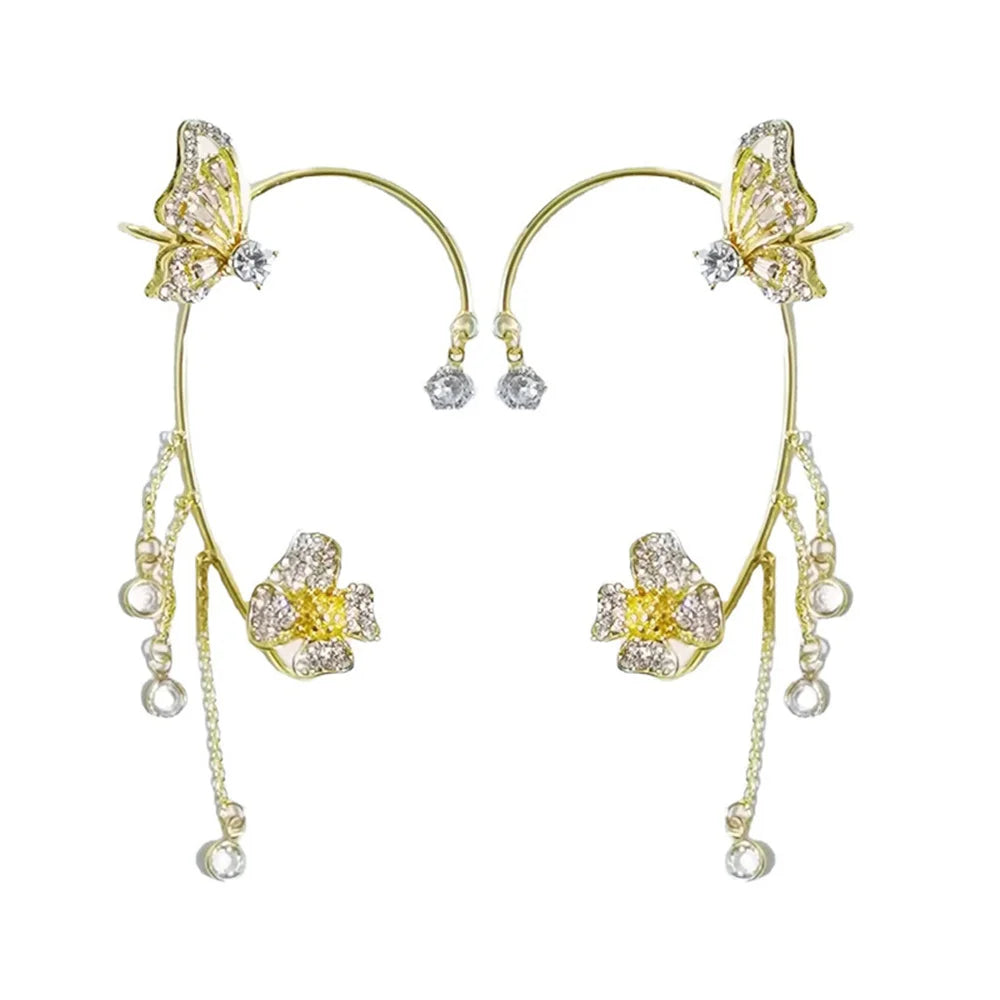 Gold butterfly earrings with yellow centers and pearl-like beads on a white background