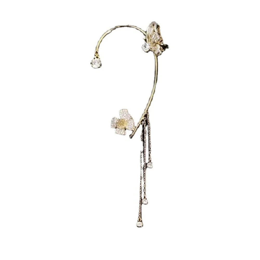 Delicate gold earring with floral and butterfly design on a white background