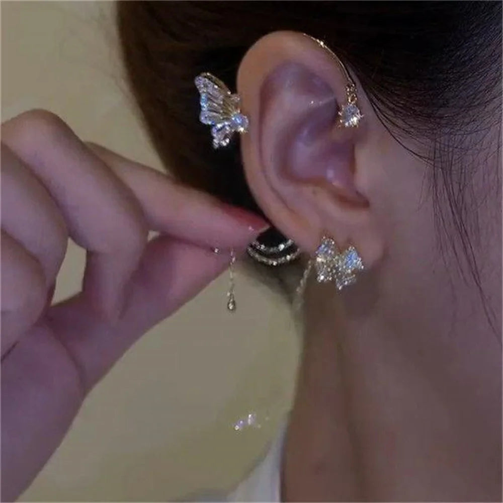 Close-up of a person wearing butterfly-shaped earrings with a blurred background