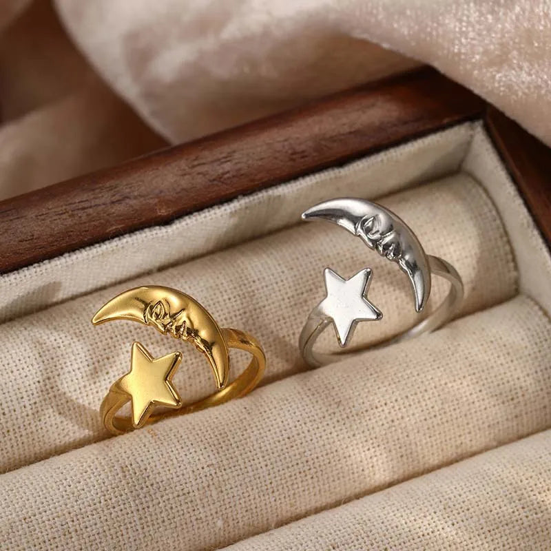 Two rings with moon and star designs on a textured surface