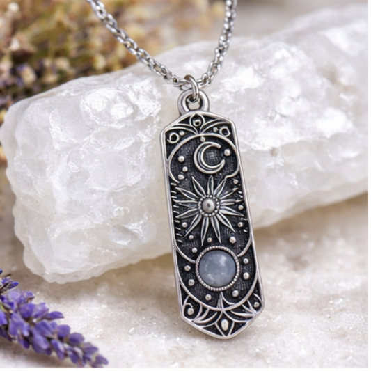 Silver pendant necklace with star and moon design on a white stone background