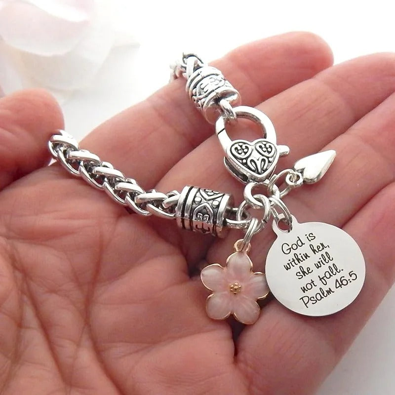 Silver bracelet with floral charm and motivational tag held in hand