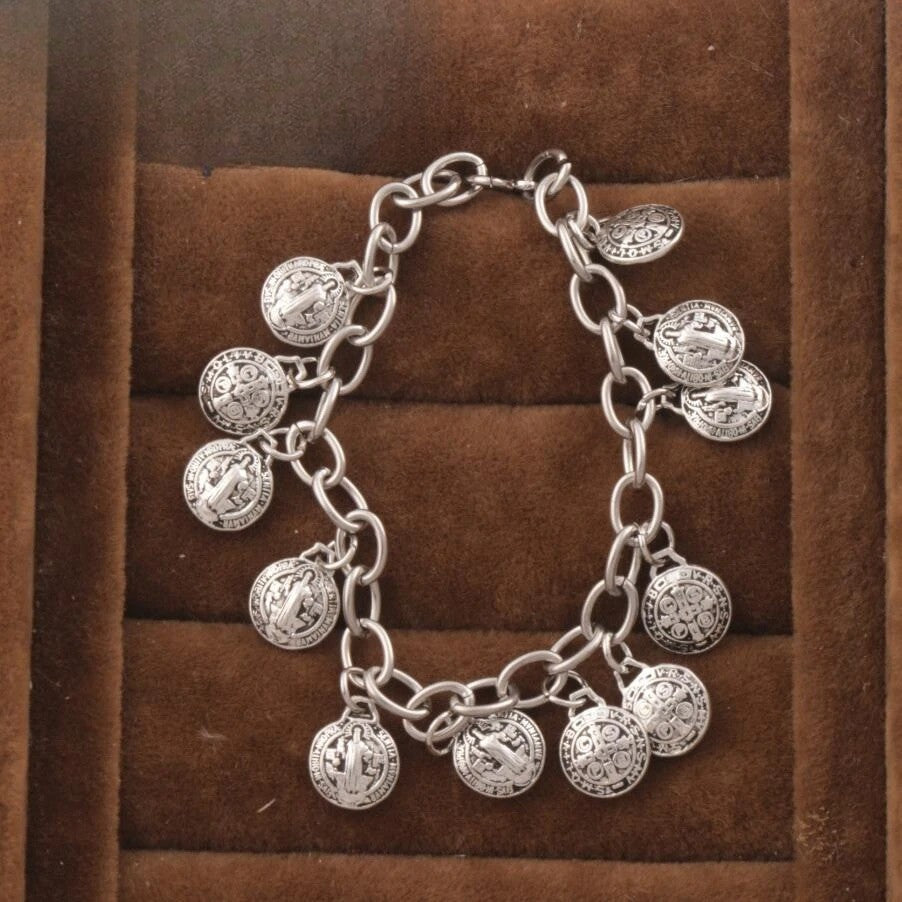 Silver charm bracelet on a brown textured background