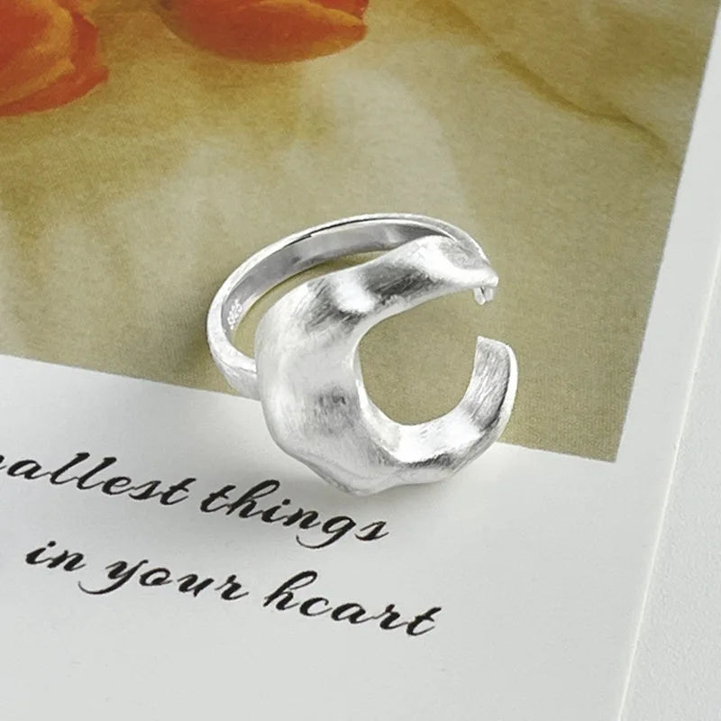 Silver ring on a card with text and floral background