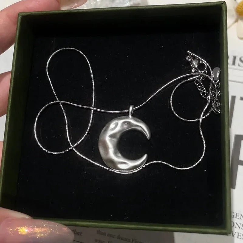 Silver crescent moon necklace in a green box