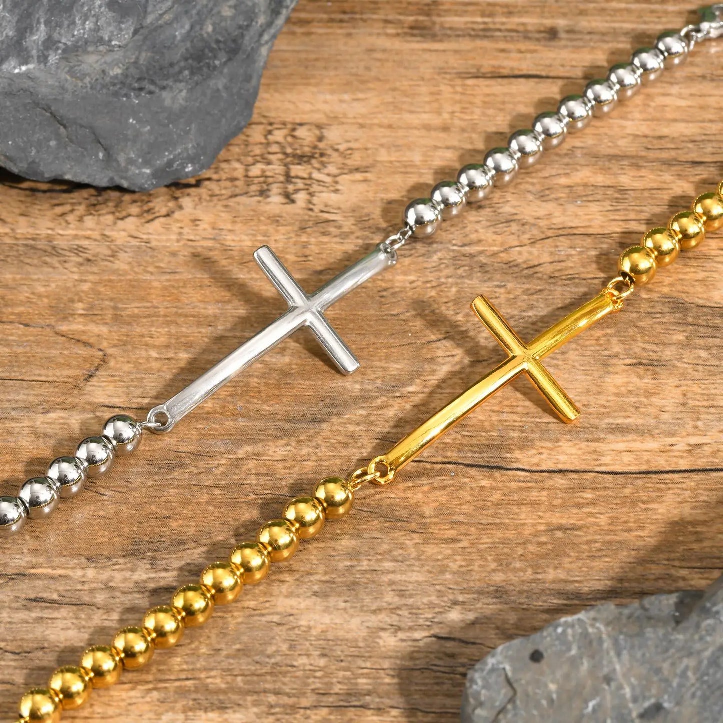 Two beaded necklaces with cross pendants on a wooden surface.