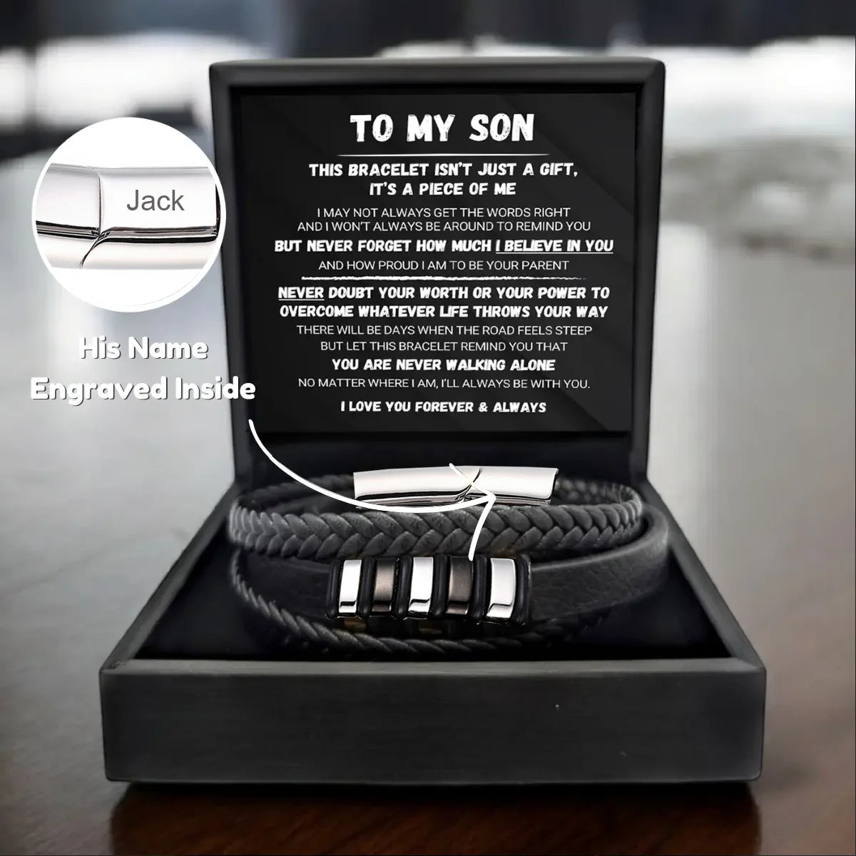 Bracelet set with engraved message and personalized name inside a black box on a wooden surface.