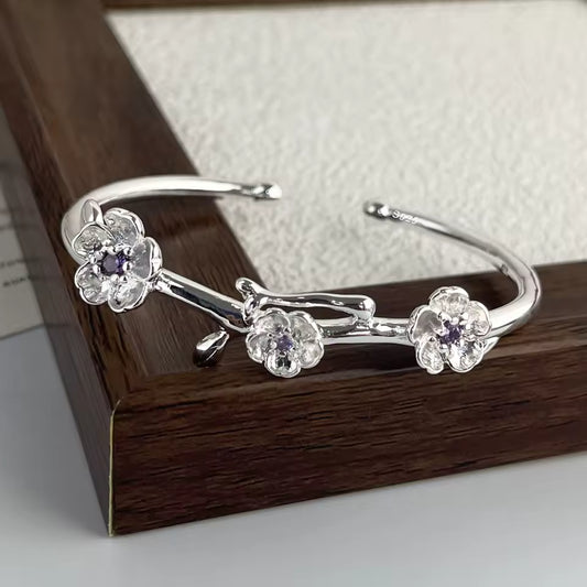 Silver floral bracelet on a wooden surface
