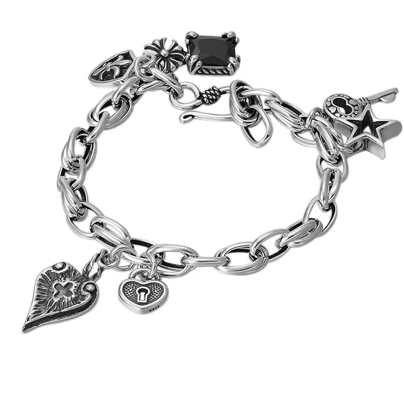 Silver charm bracelet with various charms on a white background