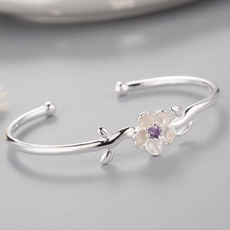 Silver bracelet with a floral design on a gray background
