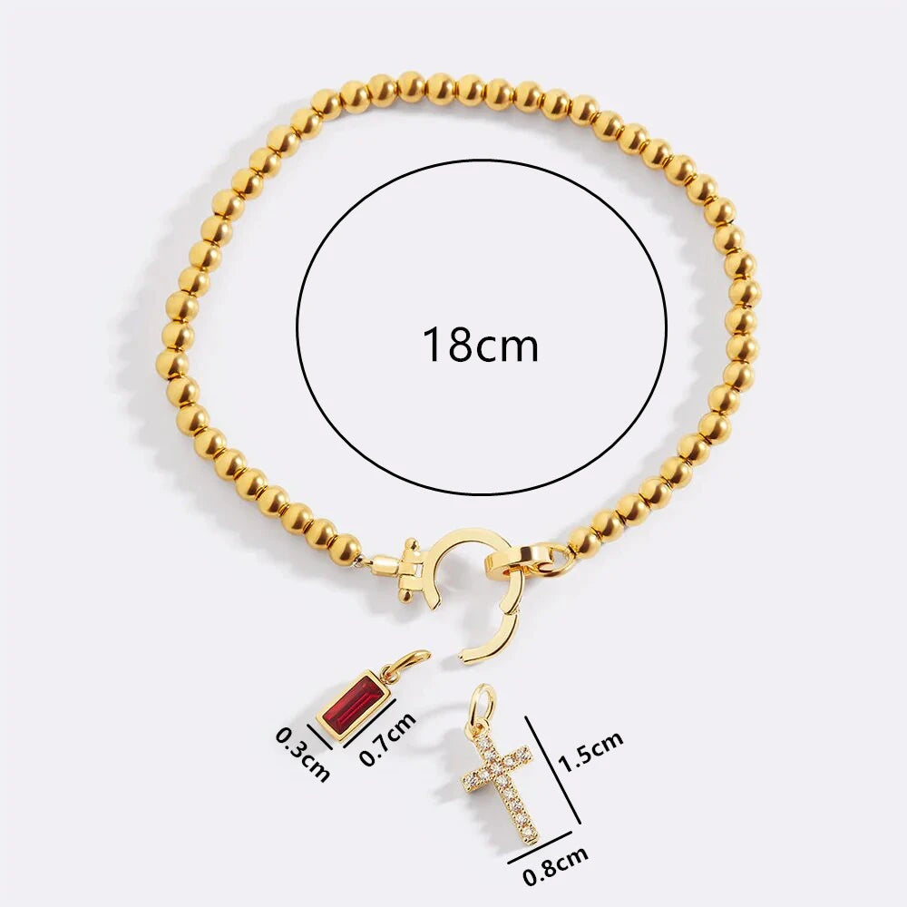Gold bracelet with charms and measurements on a white background