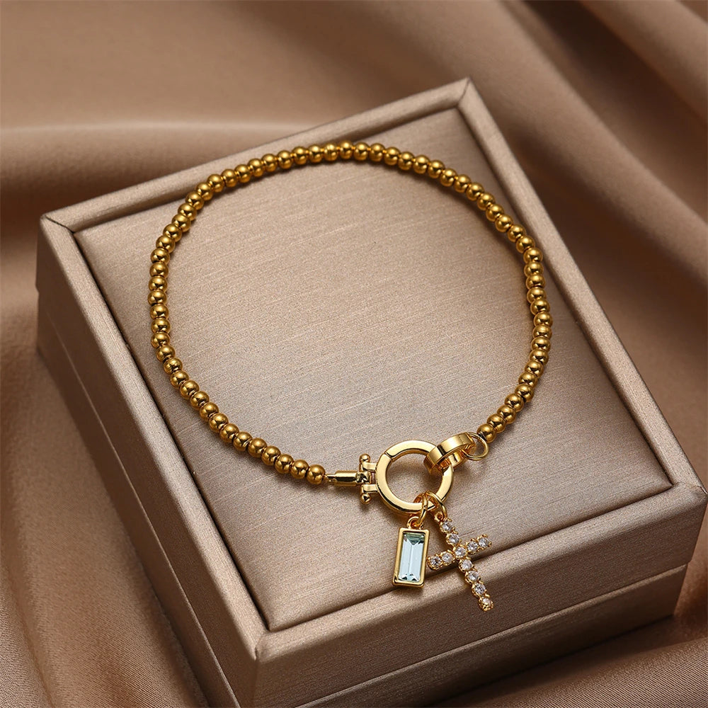 Gold bracelet with charms on a beige jewelry box