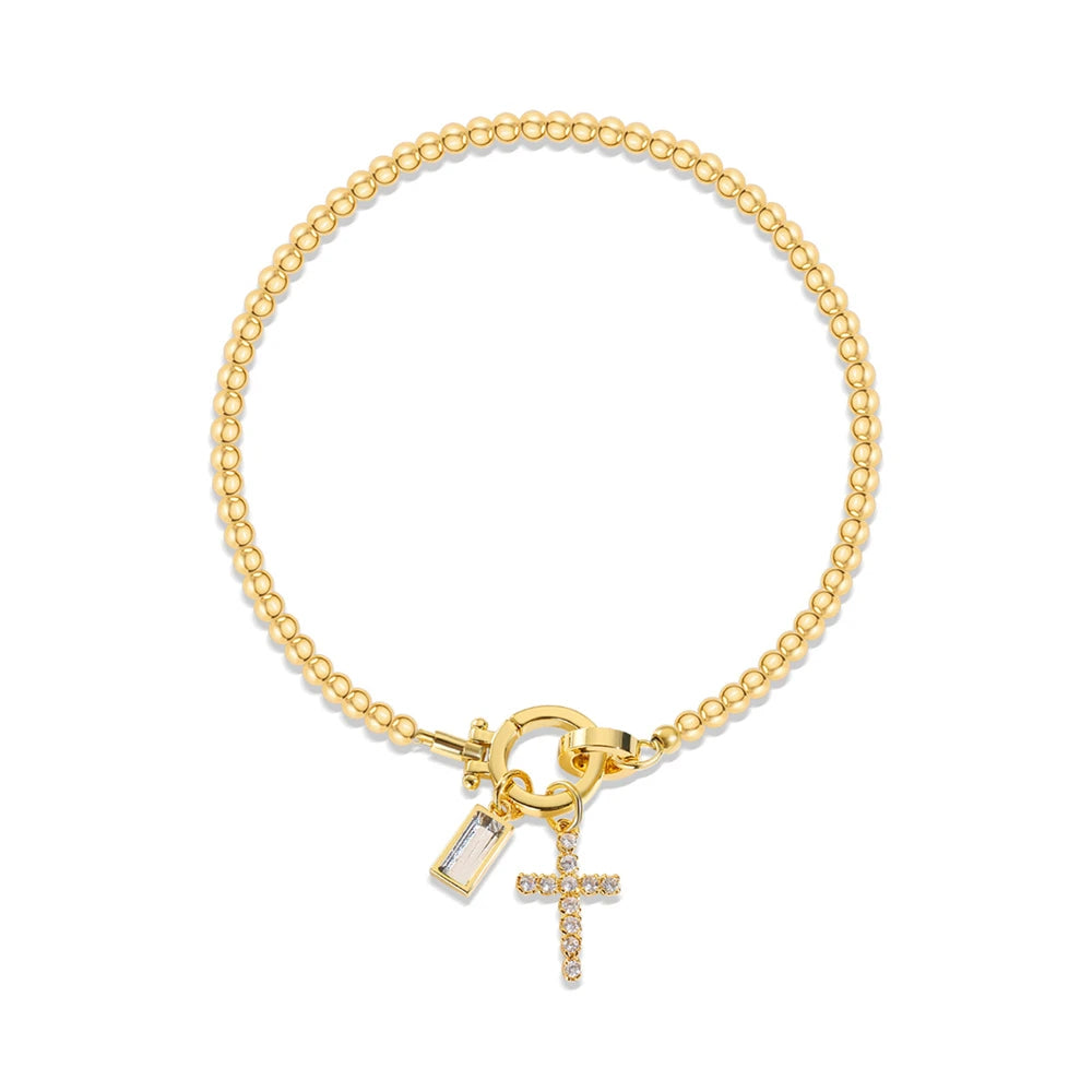 Gold bracelet with a cross charm on a white background
