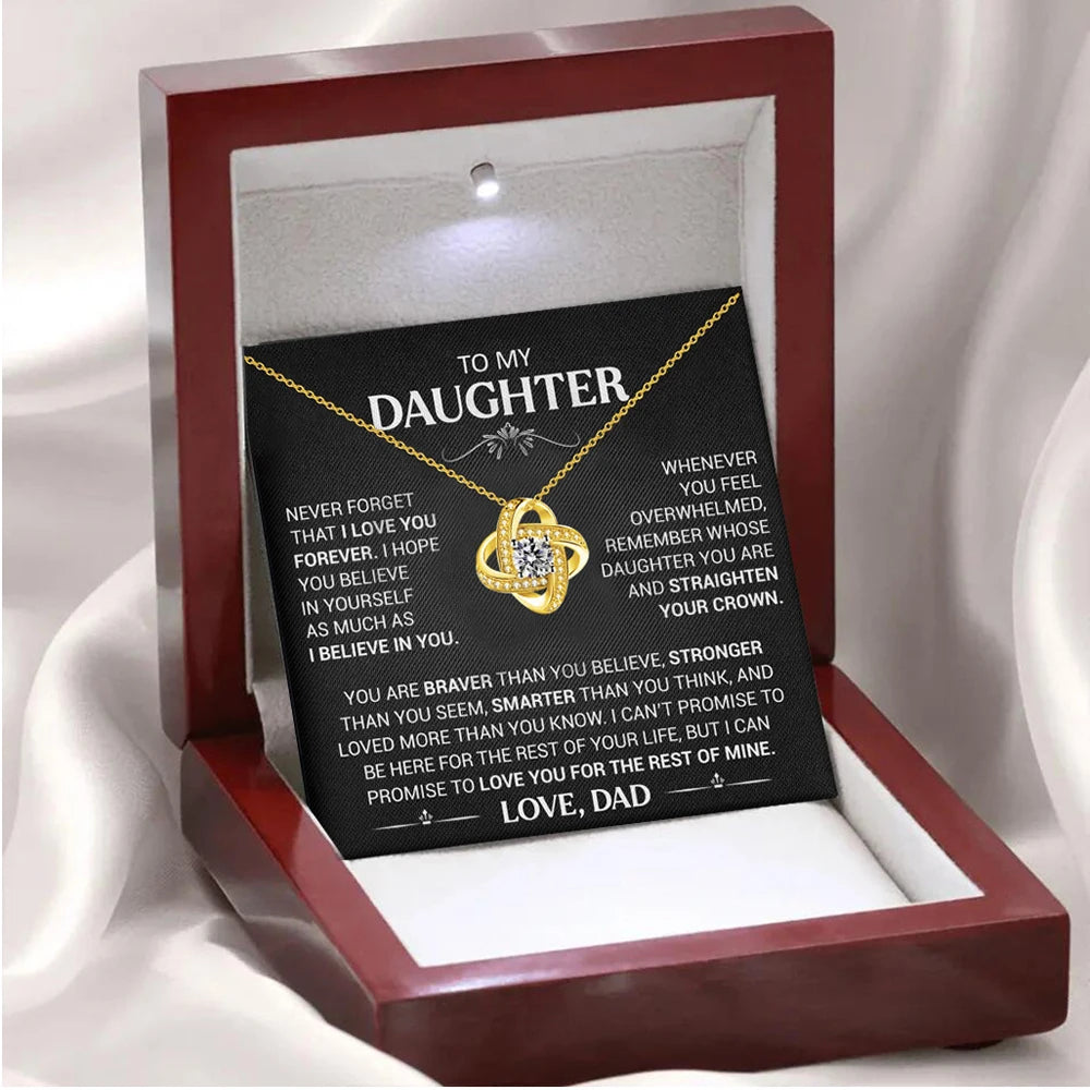Necklace with a sentimental message card in a red box on a white fabric background