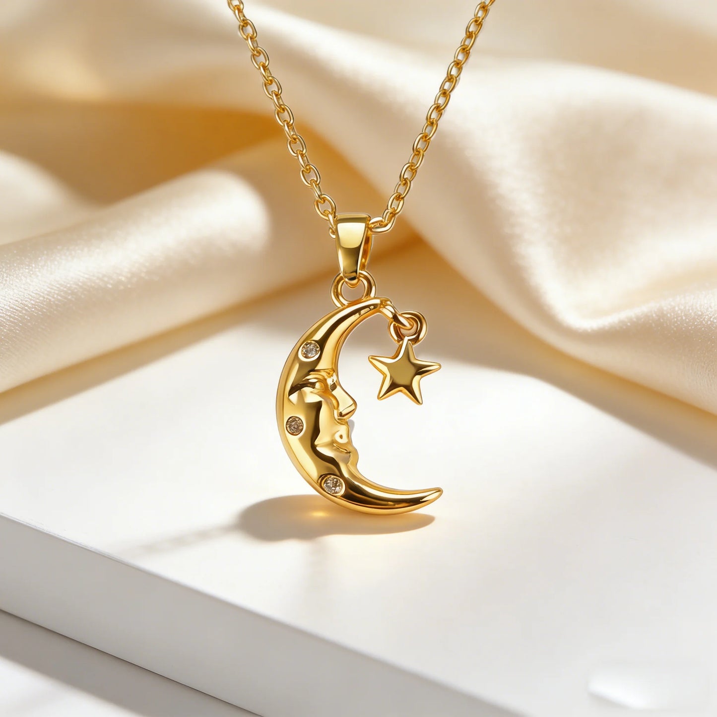 Gold necklace with a moon and star pendant on a soft beige fabric background