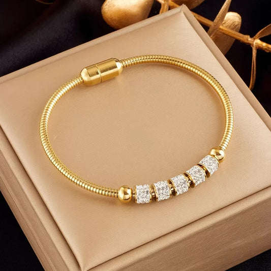 Gold bracelet with diamond accents on a beige box