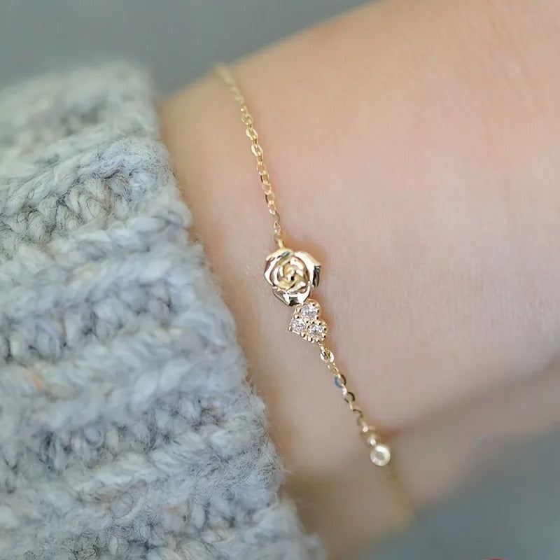 gold rose charm bracelet worn on wrist with zirconia detail