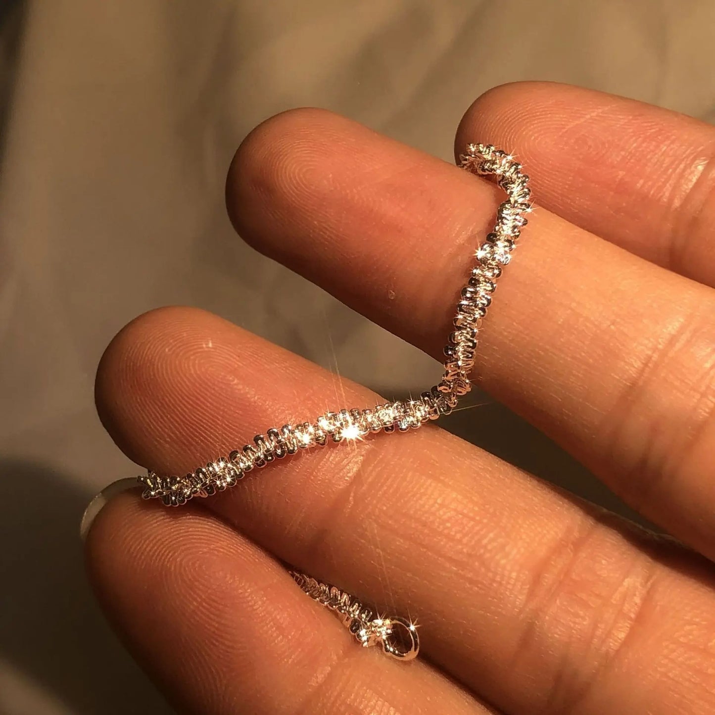 Silver ring on a finger with a plain background
