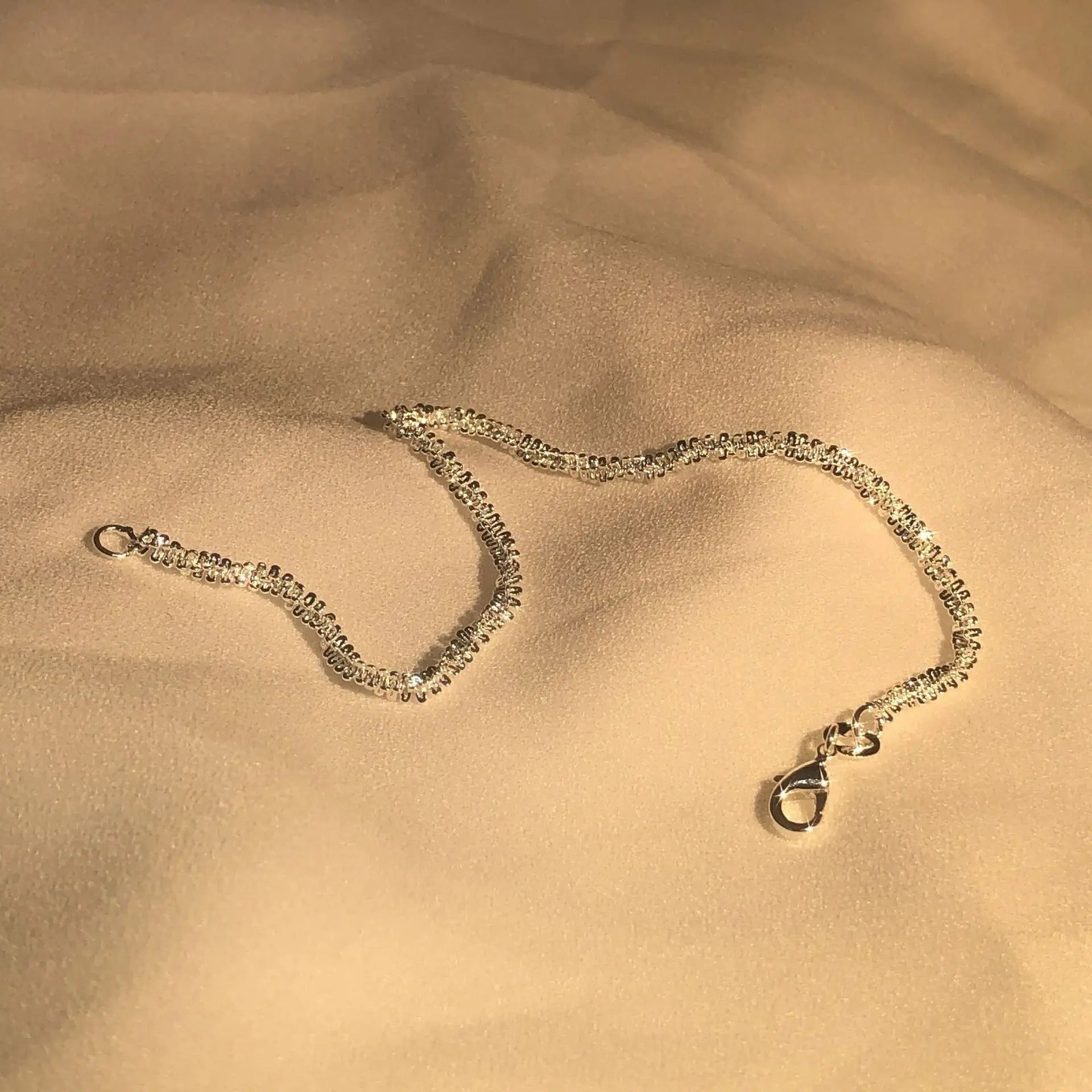 Silver bracelet on a beige fabric background