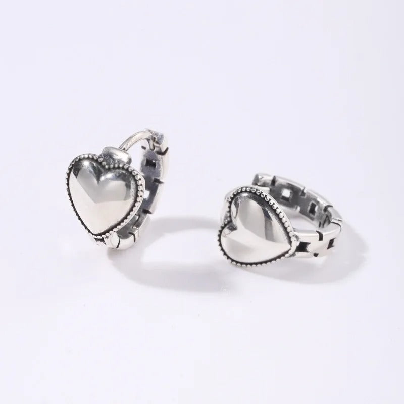 Heart-shaped silver earrings on a white background