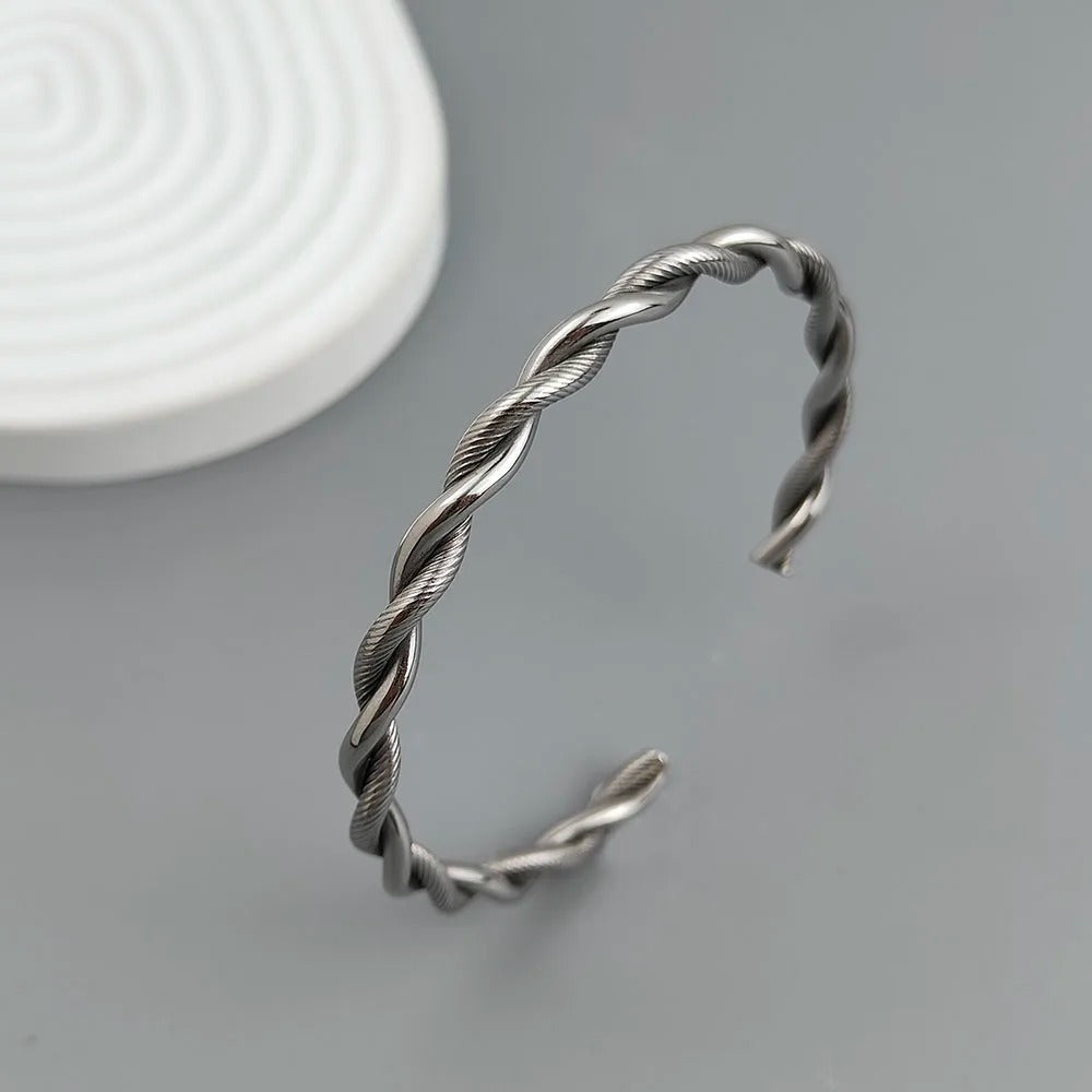 Silver twisted bangle on a gray background