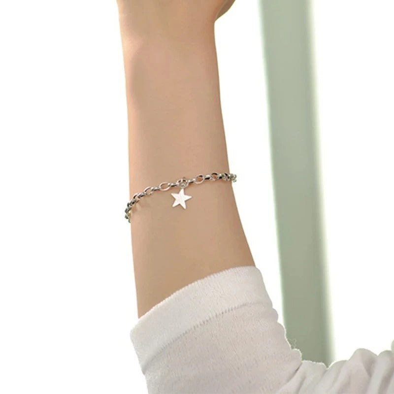 Silver star anklet on a person's ankle with a blurred background