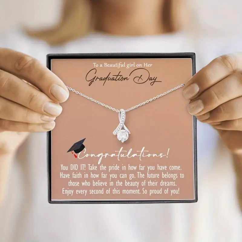 Necklace in a graduation-themed gift box held by hands with a congratulatory message.
