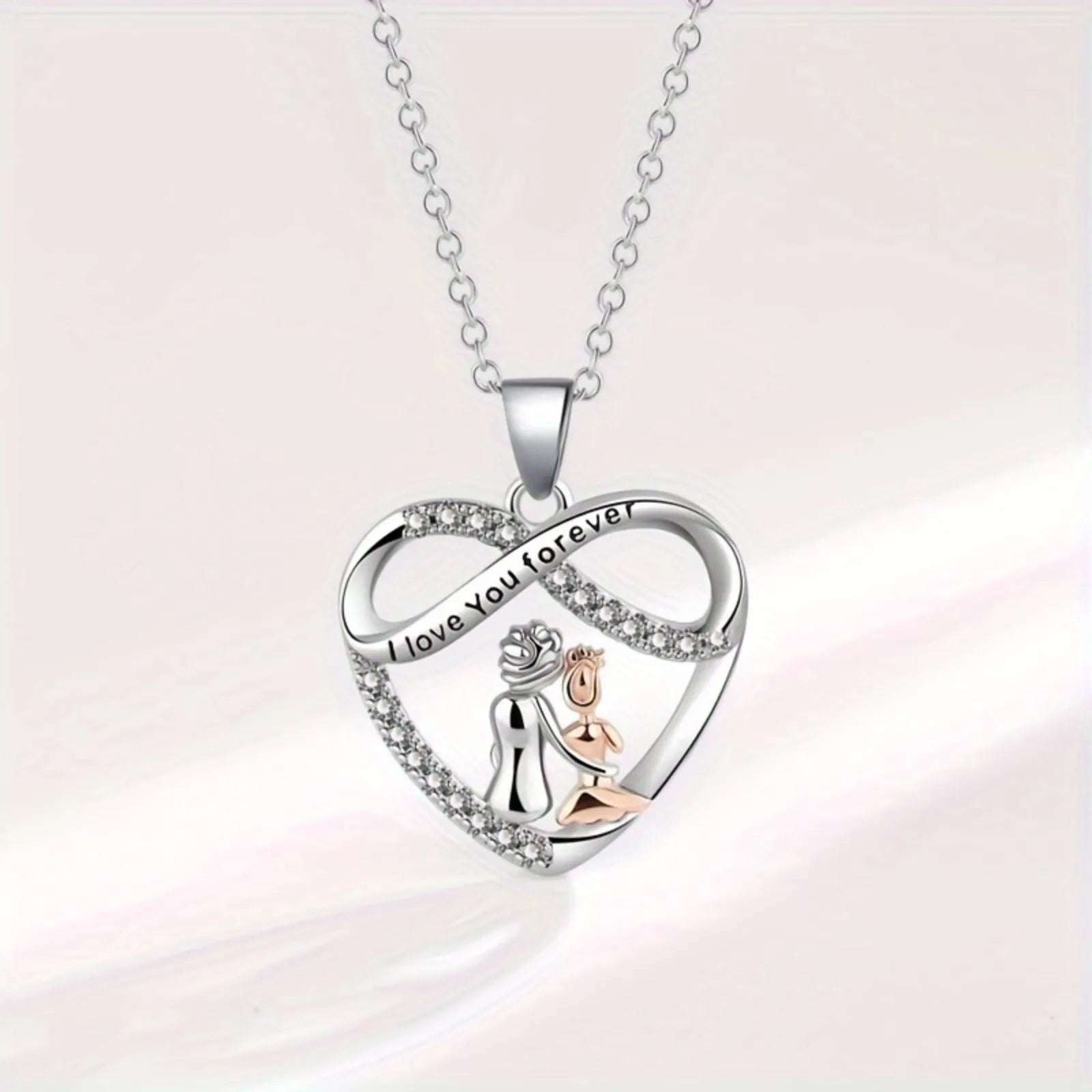 Heart-shaped pendant with 'I love you forever' engraving on a light pink background