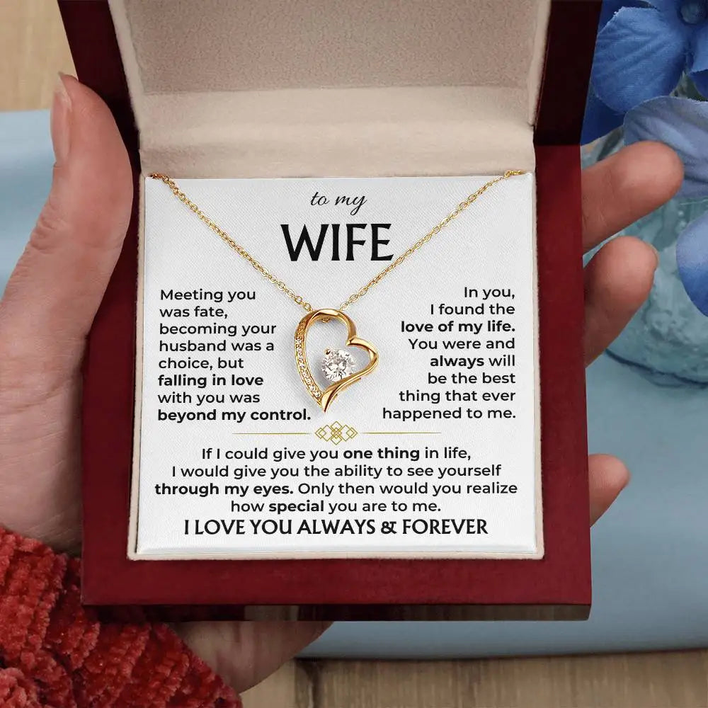 Necklace with heart design and sentimental message card held by a hand.
