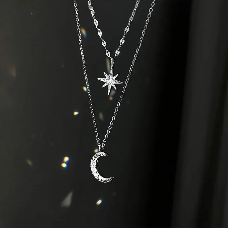 Necklace with star and moon pendants on a dark background