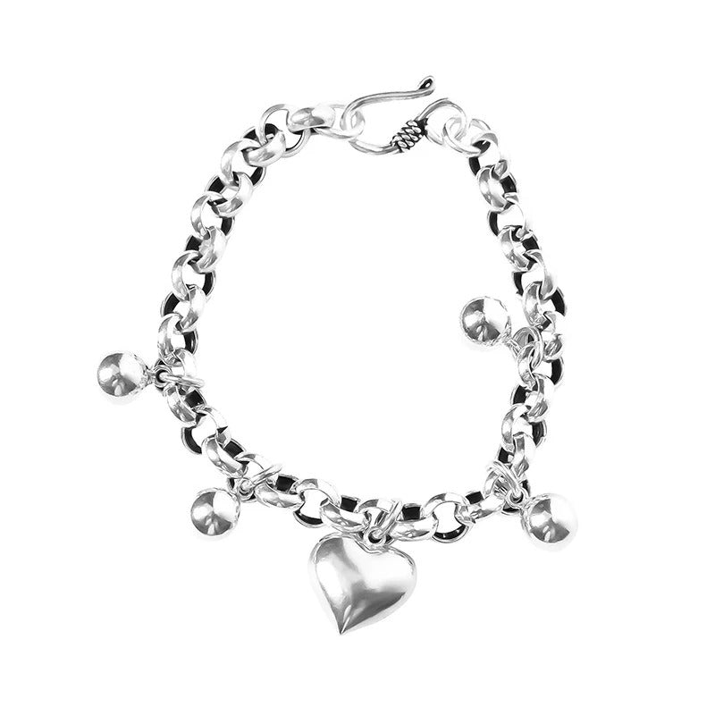 Silver bracelet with heart charm on a white background