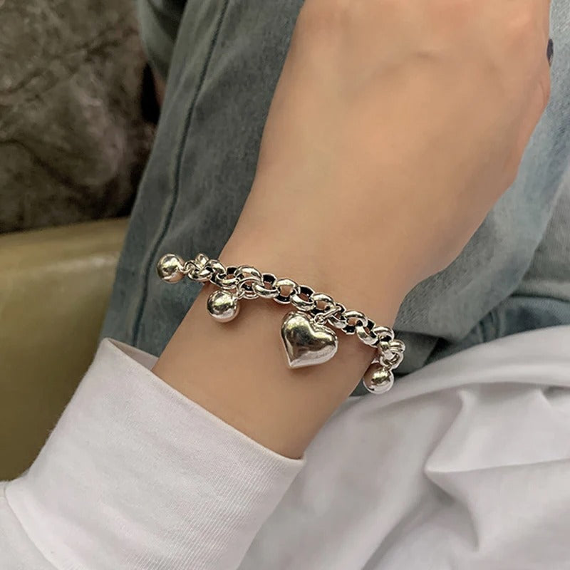 Silver bracelet with heart charm on a wrist