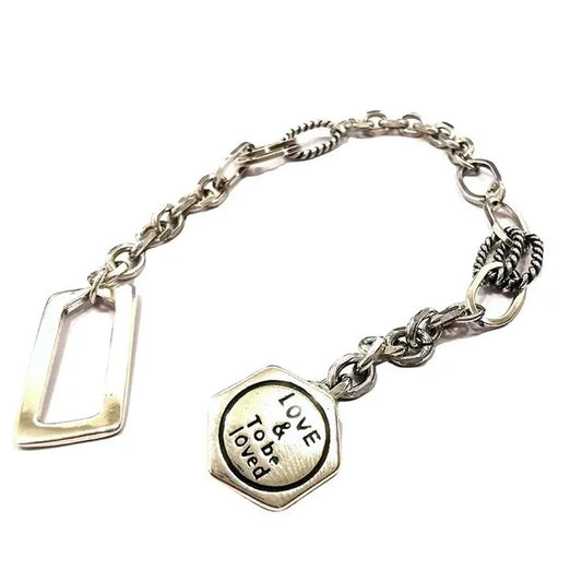 Silver bracelet with a heart-shaped charm on a white background