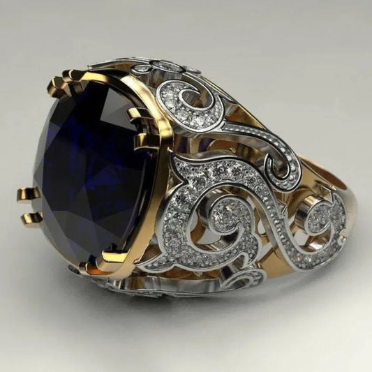 Luxury gold and silver ring with a large blue gemstone on a light gray background