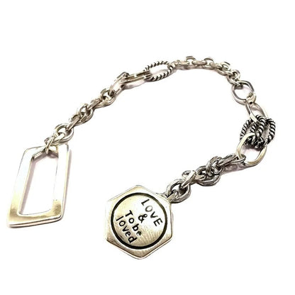 Silver bracelet with a heart-shaped charm on a white background