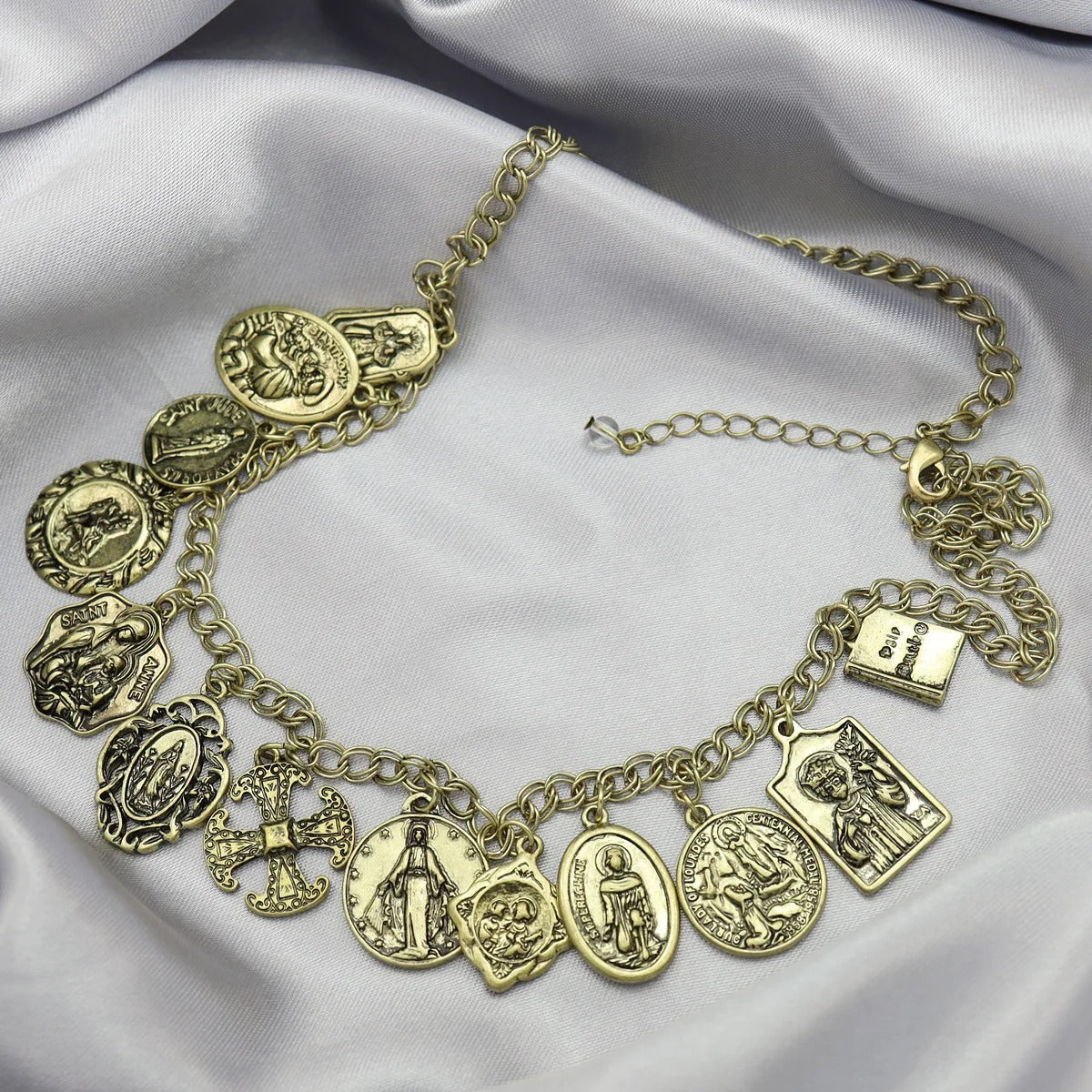 Gold charm bracelet on a soft fabric background