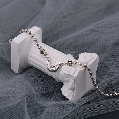 Necklace with a decorative clasp on a white stand against a gray tulle background