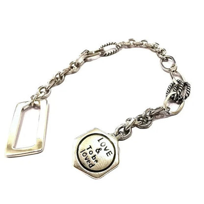 Silver bracelet with a heart-shaped charm on a white background