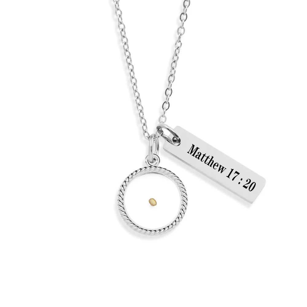 Gold necklace with circular pendant and engraved bar on a white background
